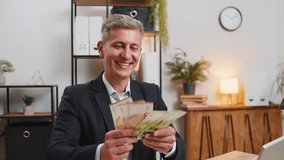 Caucasian young businessman holding fan of cash money euro banknotes celebrate, success career, lottery jackpot game winner, big income, wealth at home office workplace desk. Remote distant working. - Powered by Shutterstock - Get 15% off with code: PIKWIZARD15