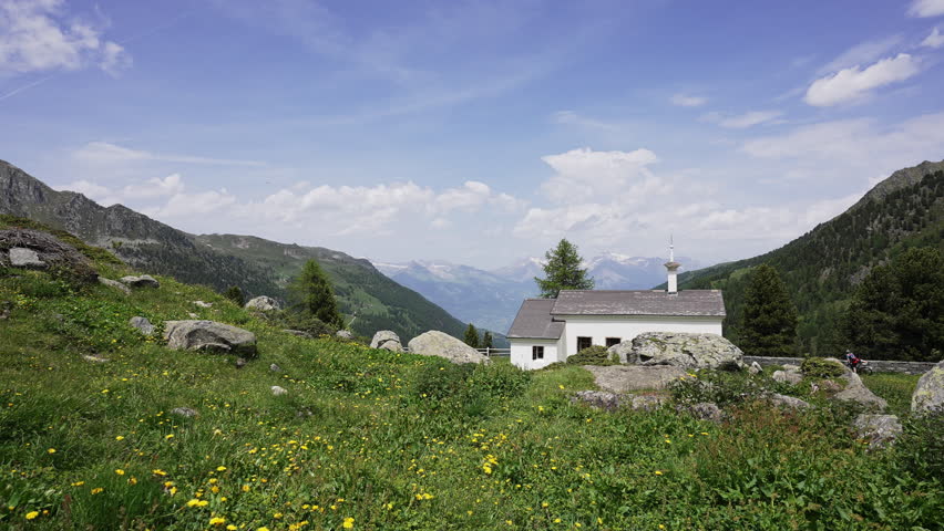 Alpine White Chapel on a Meadow Hill in the Swiss Alps