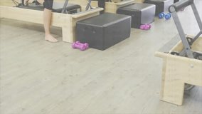 Instructor cue guiding women in pilates class kneeling reformers and lunging for core strength. Fitness, wellness, strength, group, training, design, modern - Powered by Shutterstock - Get 15% off with code: PIKWIZARD15