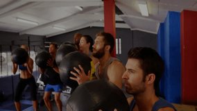 After synced squats group holding medicine balls in gym, rotating rings revealing cloud-lock icon. Fitness, strength, teamwork, digital, security, training, motion - Powered by Shutterstock - Get 15% off with code: PIKWIZARD15