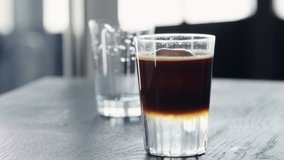 Slow motion add straw to espresso tonic ice ball in tumbler glass on black wood table closeup - Powered by Shutterstock - Get 15% off with code: PIKWIZARD15