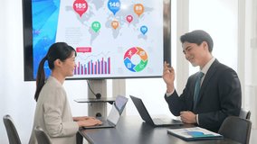 A group of business people having a meeting while looking at a large screen monitor - Powered by Shutterstock - Get 15% off with code: PIKWIZARD15