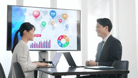 A group of business people having a meeting in front of a large screen monitor - Powered by Shutterstock - Get 15% off with code: PIKWIZARD15