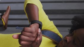 Animation of social media icons over african american woman using smartwatch on the street. Social media networking and business technology concept - Powered by Shutterstock - Get 15% off with code: PIKWIZARD15