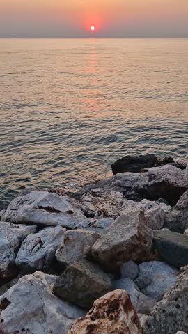 Captivating sunrise over the calm sea. Peaceful seascape at dawn with soft gradients of orange and pink on the sky reflecting on the water