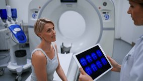 Doctor explaining CT scan results to female patient in imaging room. - Powered by Shutterstock - Get 15% off with code: PIKWIZARD15