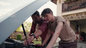 Father-son bonding moment while repairing a car. - Powered by Shutterstock - Get 15% off with code: PIKWIZARD15