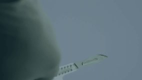 Animation of stock market data processing over mid section of a surgeon holding a medical knife. Medical healthcare and technology concept - Powered by Shutterstock - Get 15% off with code: PIKWIZARD15