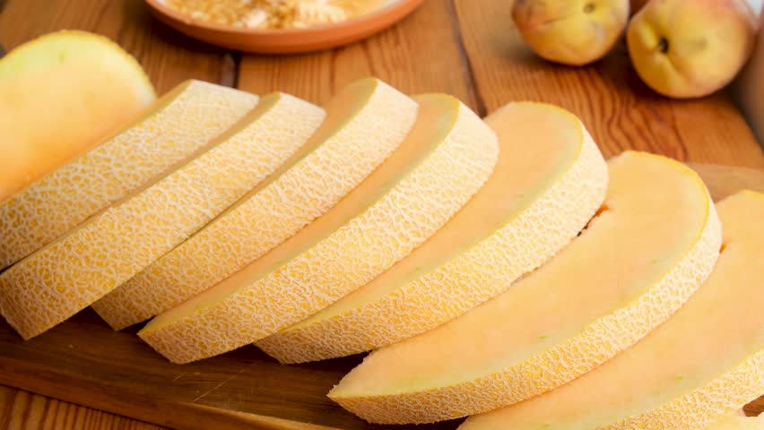 Several peoples hands grab slices of ripe juicy melon from the table. Fresh sweet fruit ready to eat after cutting. Soft, fragrant melon is a healthy seasonal snack that boosts immunity.