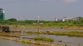 a simple wooden windmill in the middle of a salt pond - Powered by Shutterstock - Get 15% off with code: PIKWIZARD15