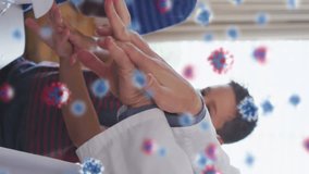 Animation of falling covid 19 cells over caucasian male doctor showing hand washing to children. Global covid 19 pandemic, science and connections concept digitally video. - Powered by Shutterstock - Get 15% off with code: PIKWIZARD15