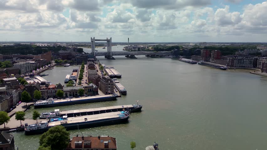 Utrecht, Utrecht region, Netherlands - 09.06.2025: Aerial view of a historic European city with a canal running beneath a clock tower building, red-tiled rooftops, solar panels, and narrow cobblestone