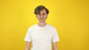 Smiling man asking money gesture on yellow studio background. Smart man smiles slyly, he has idea how earn. Profitable investments, stock market game, cryptocurrency mining. Thanks. World Savings Day - Powered by Shutterstock - Get 15% off with code: PIKWIZARD15