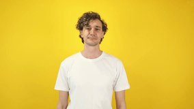 Smiling man asking money gesture on yellow studio background. Smart man smiles slyly, he has idea how earn. Profitable investments, stock market game, cryptocurrency mining. Thanks. World Savings Day - Powered by Shutterstock - Get 15% off with code: PIKWIZARD15