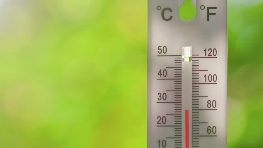 A vertical outdoor thermometer with dual Celsius and Fahrenheit scales showing rapid temperature rise from normal to overheat, indicating heatwave or extreme weather conditions
