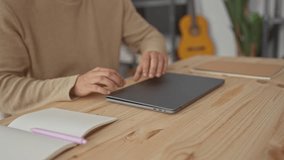 Man adjusts laptop and starts typing in home office as a hispanic young male computer freelancer, smiling contentedly. - Powered by Shutterstock - Get 15% off with code: PIKWIZARD15