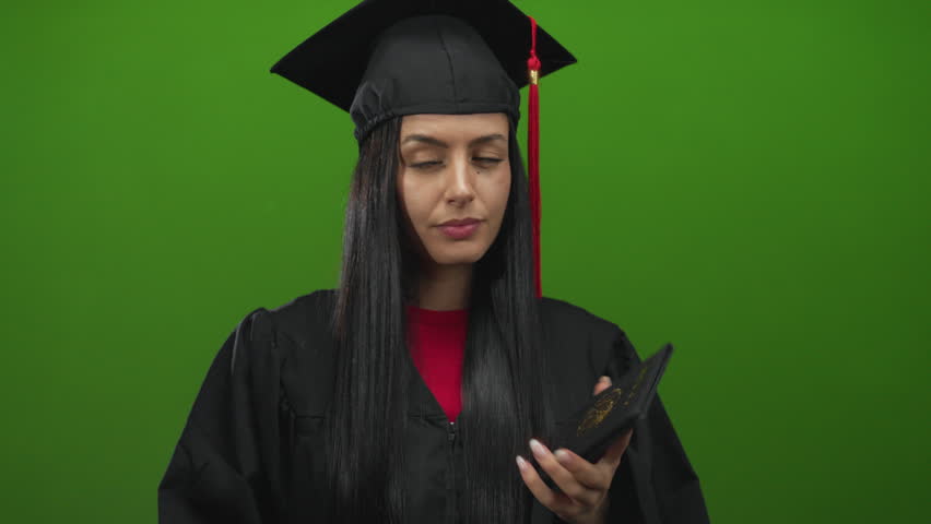 Woman in graduation gown holds mexican passport against green background, symbolizing achievement and global aspirations.