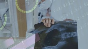 Animation of infographic interface over caucasian doctor examining patient x-ray. Digital composite, multiple exposure, report, business, global, medical, healthcare, technology concept. - Powered by Shutterstock - Get 15% off with code: PIKWIZARD15