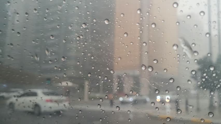 Side window view from a taxi with rain droplets, gloomy weather