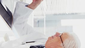 Animation of glowing lights over caucasian male doctors with computer. Global medicine, healthcare and data processing concept digitally generated video. - Powered by Shutterstock - Get 15% off with code: PIKWIZARD15