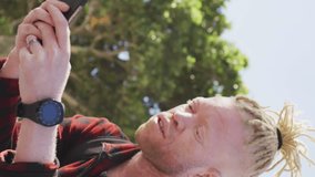 Animation of 5g texts over albino african american man scrolling on cellphone and using smartwatch. Digital composite, multiple exposure, telecommunication and technology concept. - Powered by Shutterstock - Get 15% off with code: PIKWIZARD15