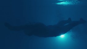 Professional swimmer trains in the pool, underwater view. Female swimmer dives and swims fast during swimming work out in the empty morning pool. Close up underwater view - Powered by Shutterstock - Get 15% off with code: PIKWIZARD15