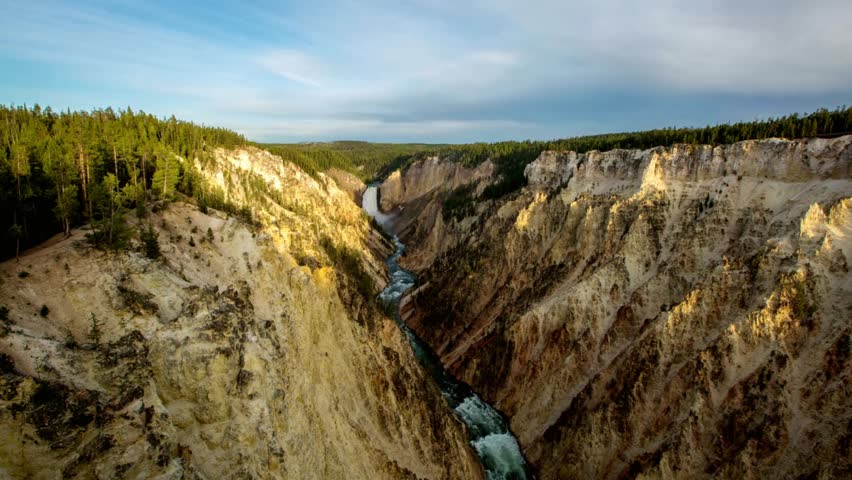 A scenic canyon landscape features a flowing river and rocky cliffs