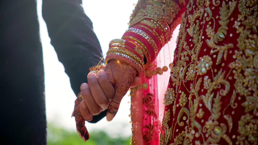 Traditional henna painted bridal hand. Red color is the traditional Indian clothes, Elements of hindu wedding. 