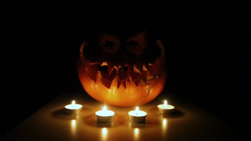A spooky Halloween animation featuring a scary-faced pumpkin on a table with eerie red candlelight, perfect for horror-themed projects, Halloween promotions, and dark fantasy visuals. - Powered by Shutterstock - Get 15% off with code: PIKWIZARD15