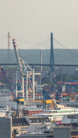 Aerial timelapse of Hamburg cargo port, showcasing container terminals, cranes and cargo ships on the Elbe River. Working wind power stations. Boats and vessels pass by, maritime panorama. Germany