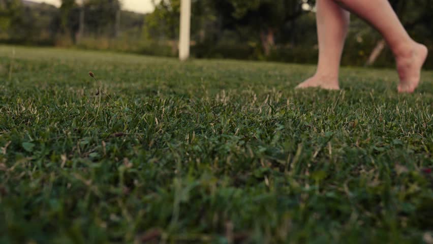 Young woman walking on a grass in the morning.