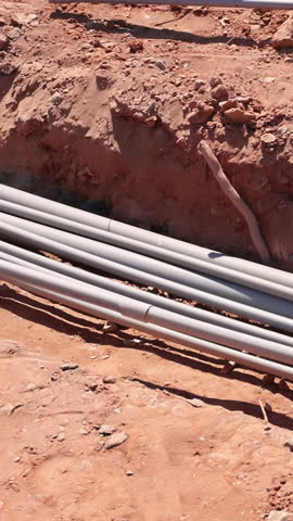 Workers are installing electrical piping at construction site, showcasing groundwork for utilities