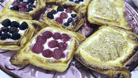 Freshly baked Raspberry, Blackberry and Sliced Pear Danish Pastries on a serving tray. Catering concept for all social occasions. 4k60. - Powered by Shutterstock - Get 15% off with code: PIKWIZARD15