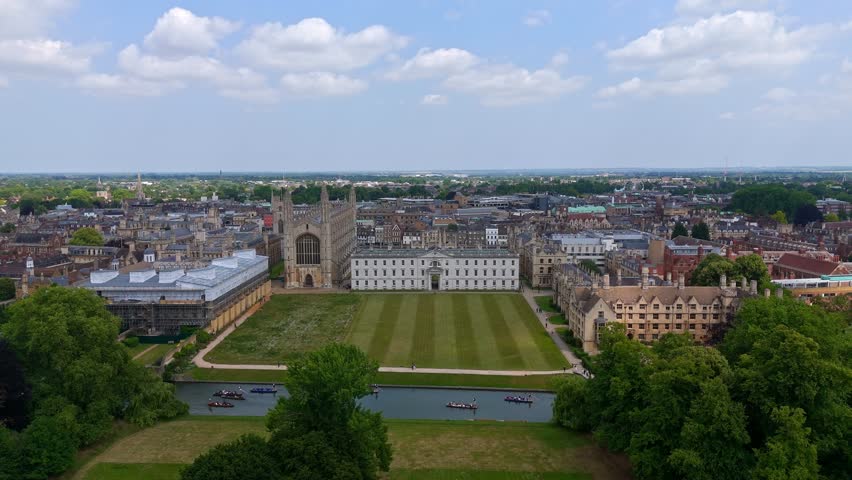 Aerial view of Cambridge University campus with the river Cam and boats navigating on a sunny day