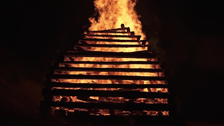 Intense Fire Flames in Dark Night, Slow Motion Tilt-Up of Wood Pyre Burning