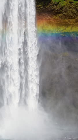 Aerial Skogafoss Waterfall in Iceland, complete with a rainbow view. Vertical