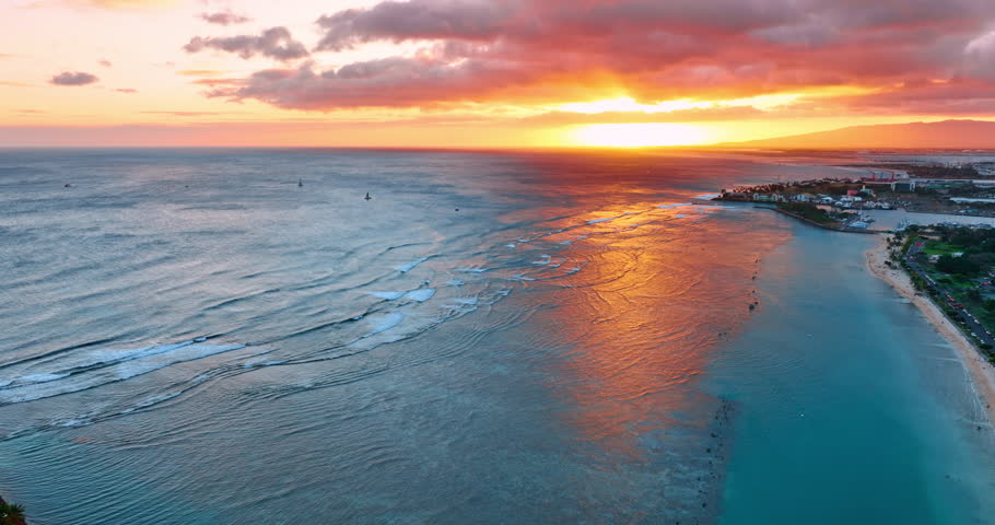 Waterscape of the Pacific Ocean reflecting the light of setting sun. Footage at the shore of Honolulu, Hawaii, USA at sunset.