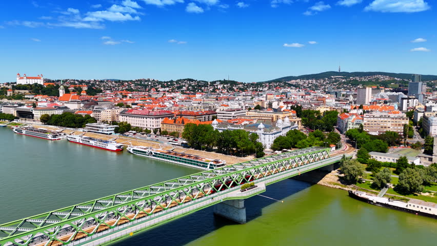Approaching a metal Old Bridge with a tram going by. Aerial perspective on the beautiful historical part of Bratislava, Slovakia.