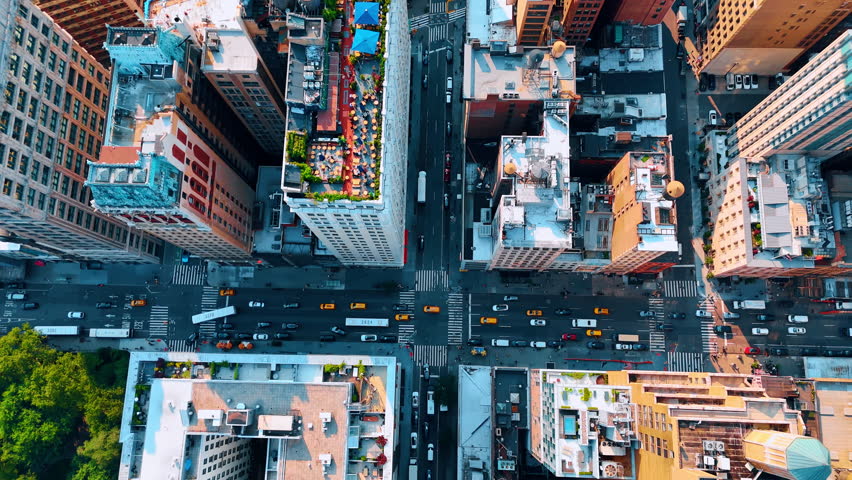 Yellow cabs move in the flow of cars by the multi-lane street. Top view on the traffic in New York. USA.