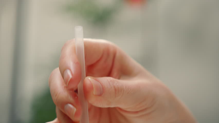 Extreme close up view of iced tea or coffee with matcha woman mouth drink from straw.
