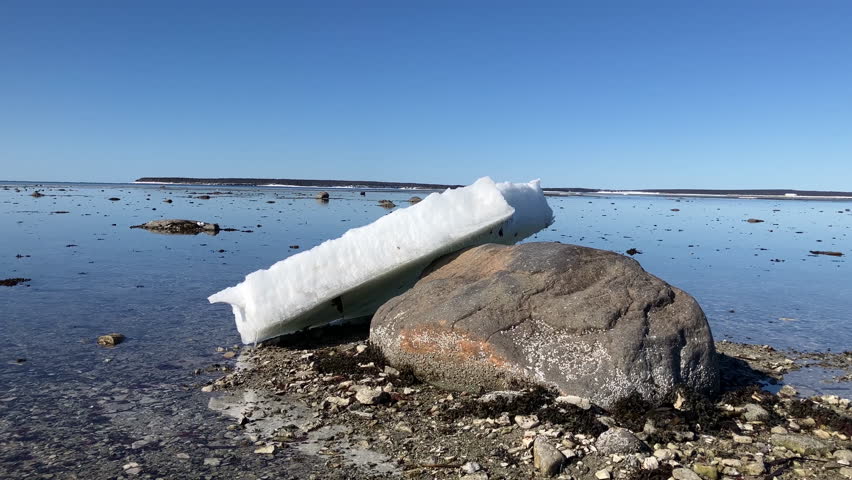 Large Piece of ice Leaning on a Large Rock in Navots Bay, on Anticosti Island, Quebec, Canada