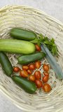 Vibrant summer vegetables and herbs, freshly picked from a balcony garden, rest in a woven basket - of cucumbers, tomatoes, spring onions and basil - Powered by Shutterstock - Get 15% off with code: PIKWIZARD15