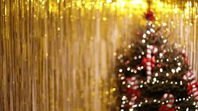 A Defocused Close Up Of A Christmas Tree With Golden Tinsel Wall And Blurred Lights
Festive interior with a decorated Christmas tree in the background, candy cane ornaments, and a golden tinsel wall - Powered by Shutterstock - Get 15% off with code: PIKWIZARD15