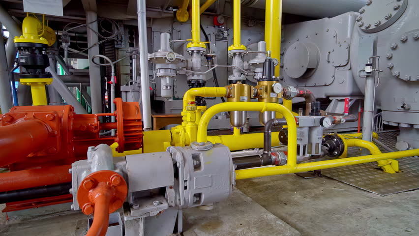 Industrial compressor and mechanical equipment with yellow pipes in enclosed facility