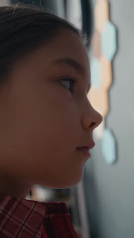 Vertical of young Asian female student reaching up to interact with chalk-drawn solar system diagram during astronomy lesson in modern, well-equipped classroom