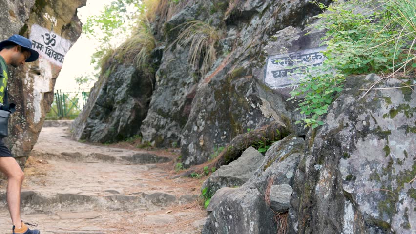 Hikers trekking in the mountains along the trail to Madmaheshwar Temple, near Ransi Village, Uttarakhand, India.