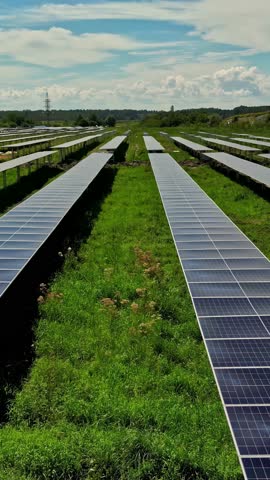 Rows Of Solar Panels Installed In Green Field - Vertical Shot