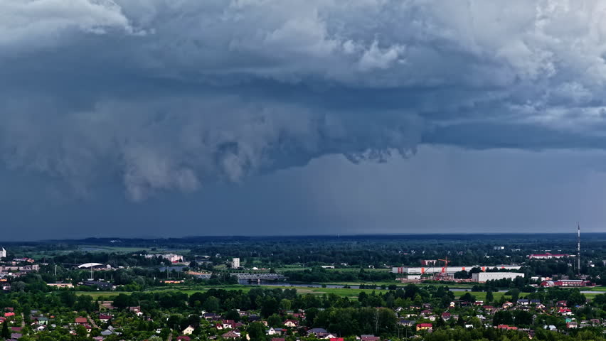 Storm clouds rolling over fields and rural countryside in moody natural light, climate change natural disaster