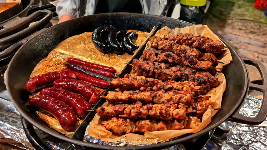 Cooked meat skewers with crispy edges and darkened surface ready to eat on plate