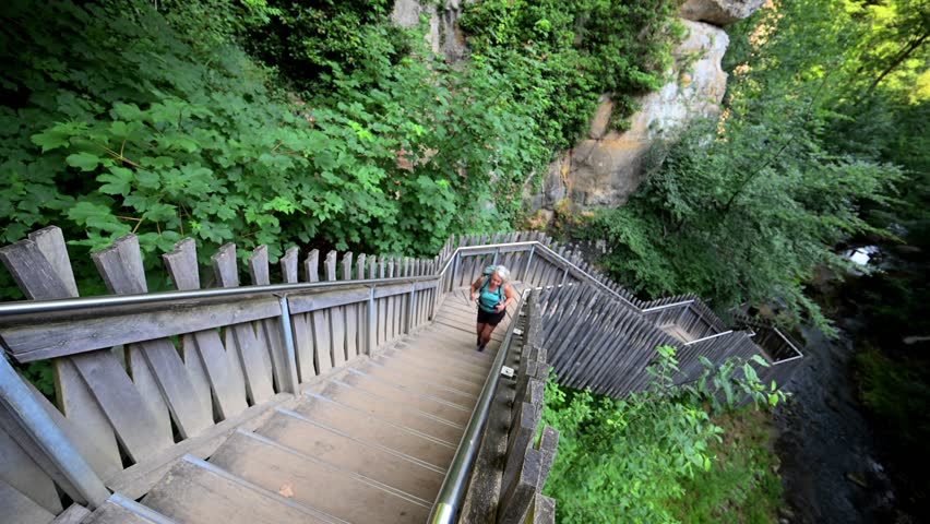 Female hiker at the Mullerthal Trail Schiessentümpe waterfall in Luxembourg	
